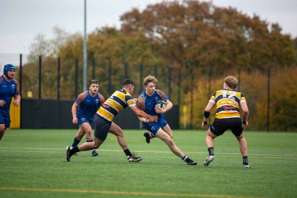 Jóvenes jugando rugby en un campo